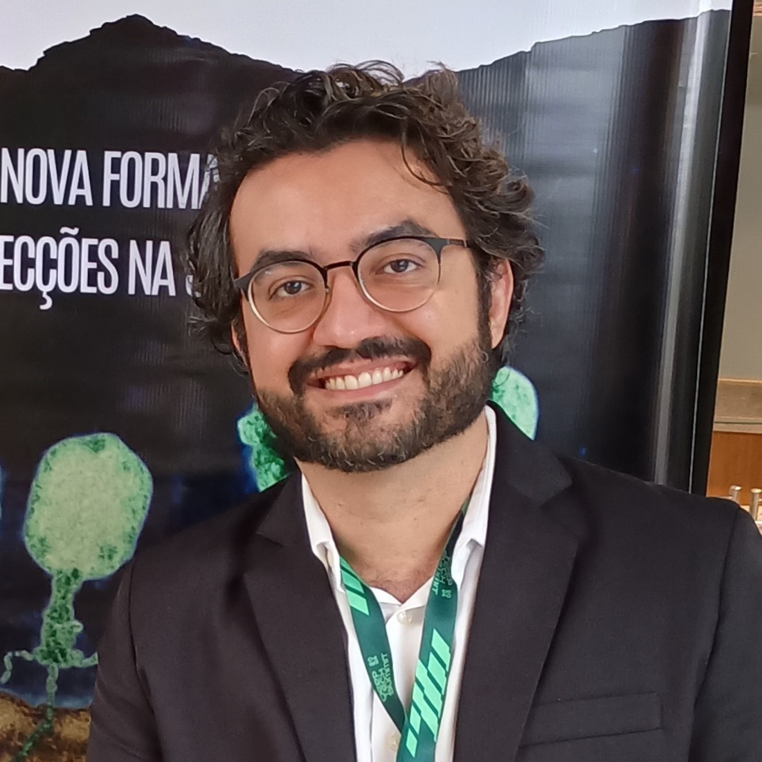 Foto de luciano Queiroz, com cabelos curtos e escuros, sorrindo e olhando diretamente para a câmera.